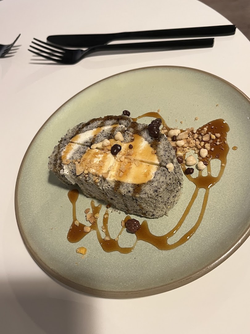 Un dessert roulé au sésame noir, noix et caramel